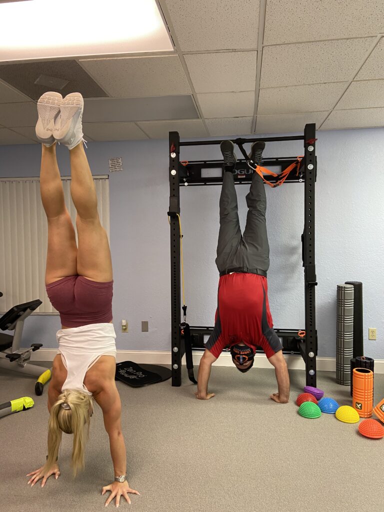 Athlete and chiropractor doing a handstand.