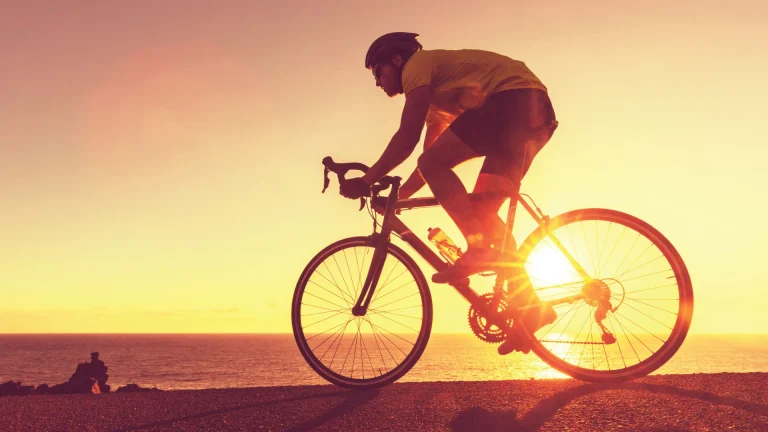 Cyclist riding at sunset, symbolizing how chiropractic and soft tissue care support pain free performance.