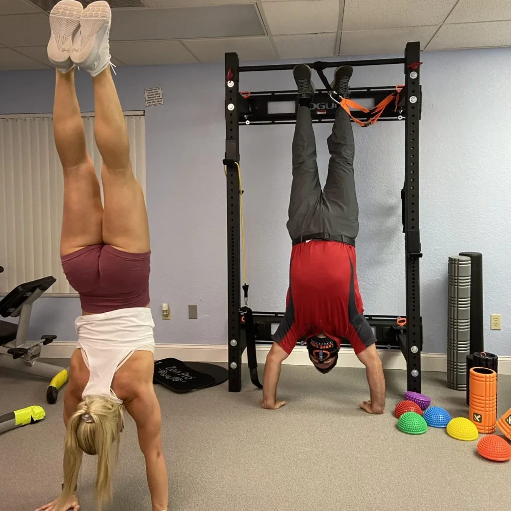 Athlete and chiropractor doing a handstand to achieve their fitness goals