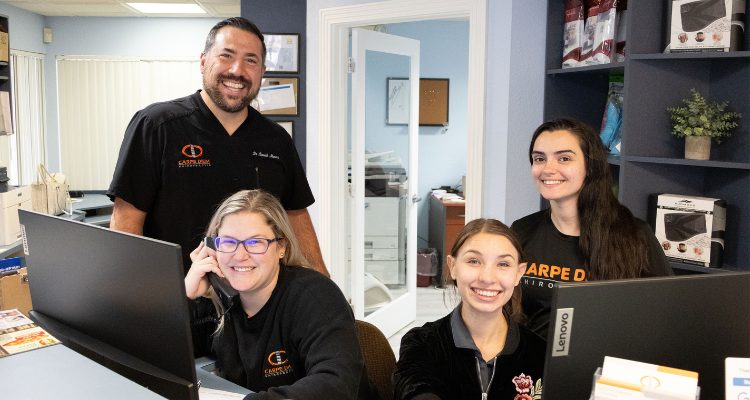 Carpe diem chiropractic team smiling inside the clinic reception area